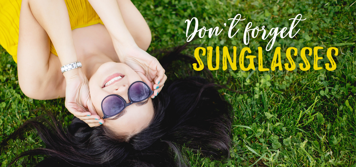 woman lying in grass with sunglasses on